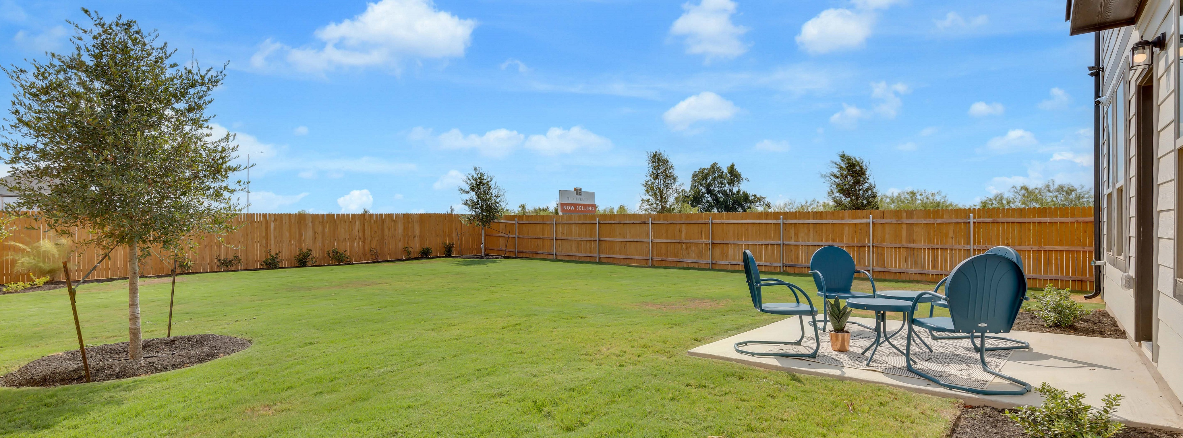A backyard with chairs and a table.