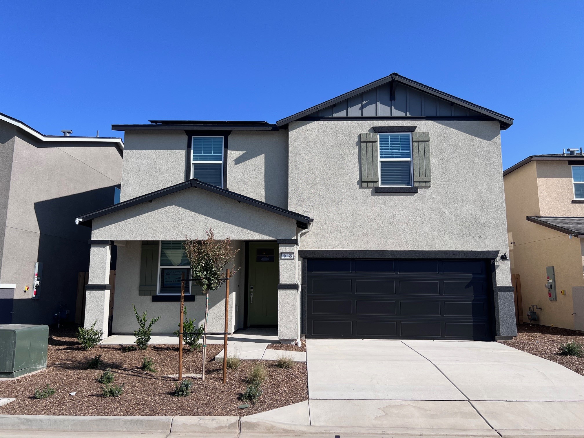 A grey house with a garage.