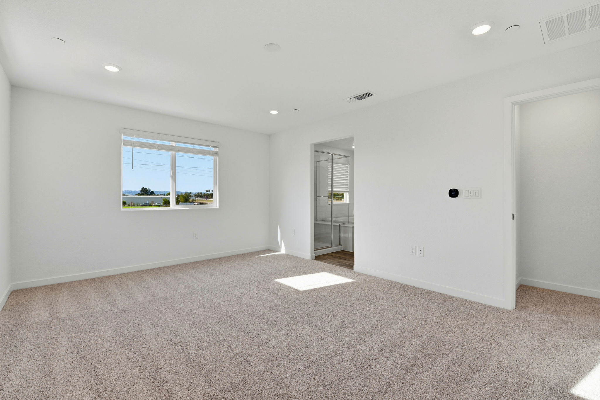 A room with a carpet and a window.