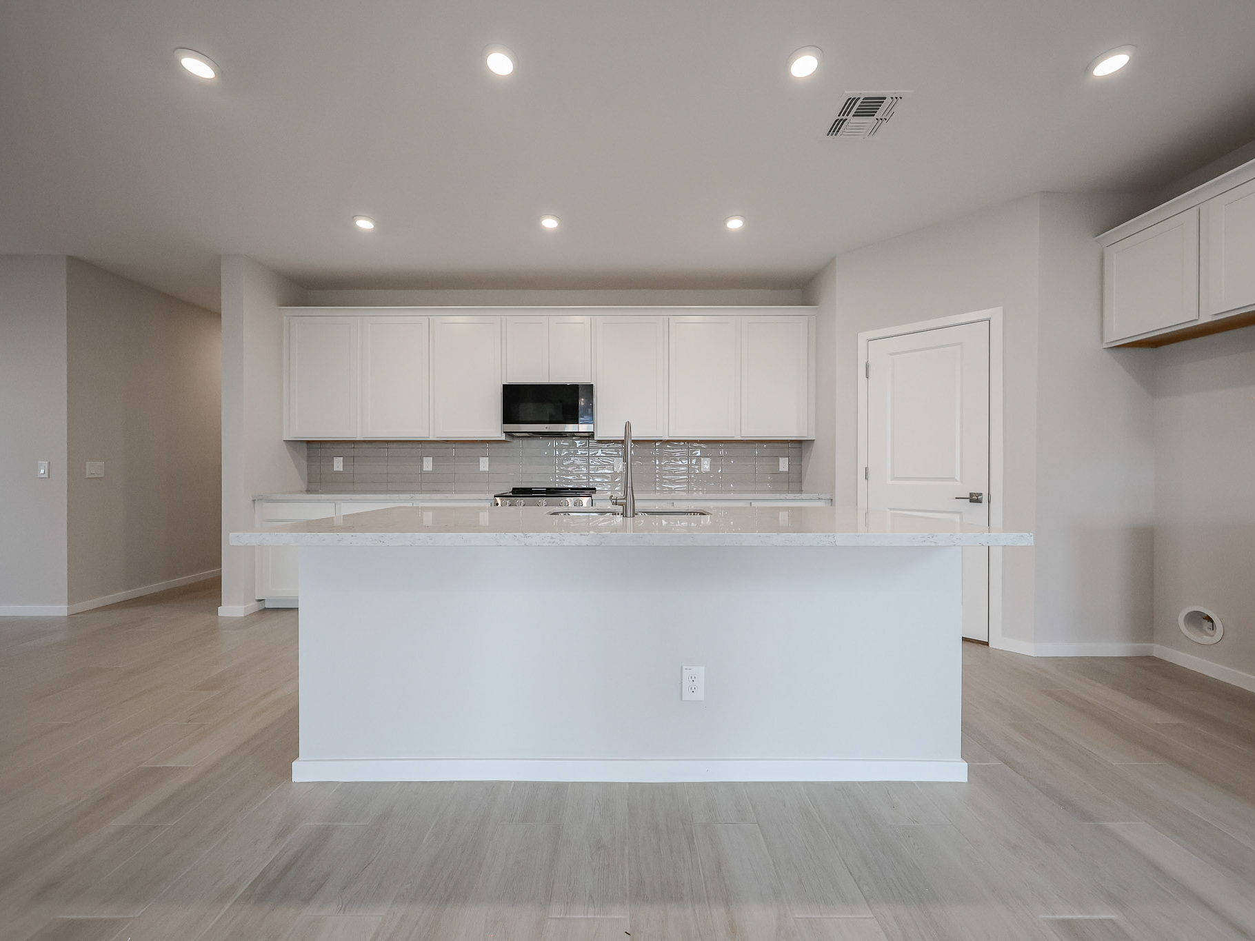 A kitchen with white cabinets.