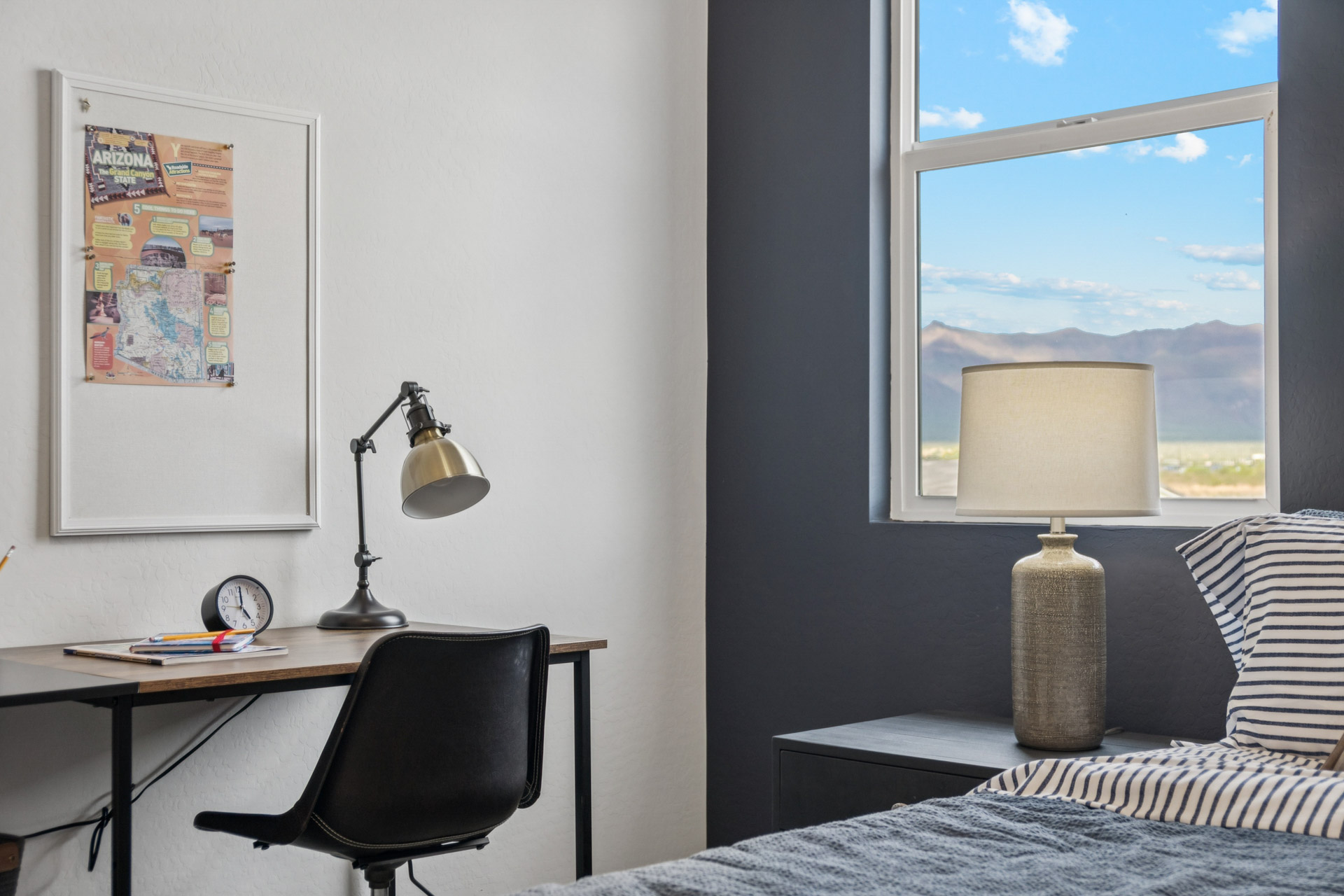 A bedroom with a desk and a lamp.