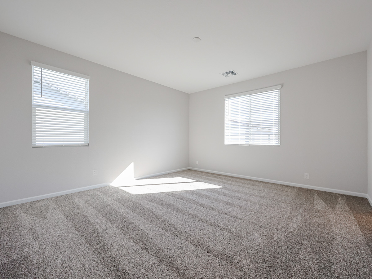 A room with a carpet and windows.