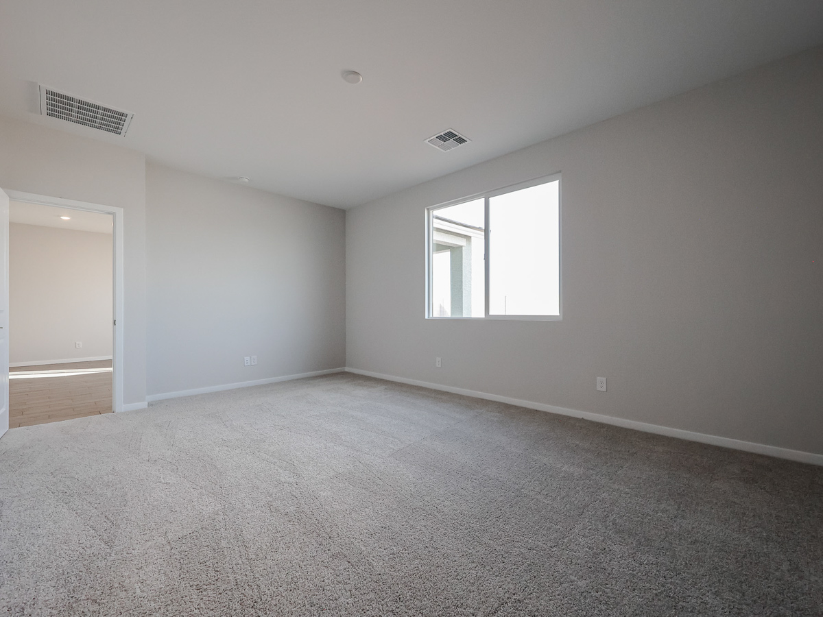 A room with a carpet and a window.