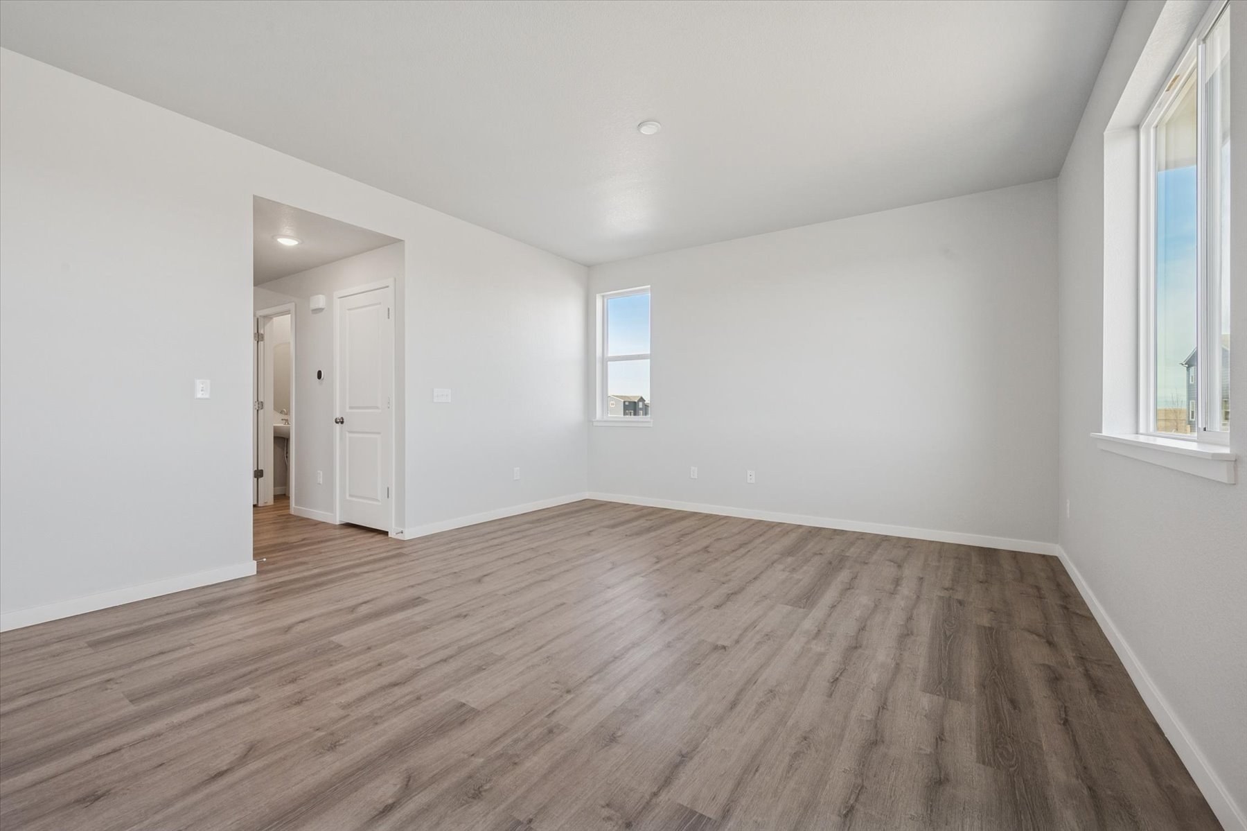 A room with white walls and wood floors.