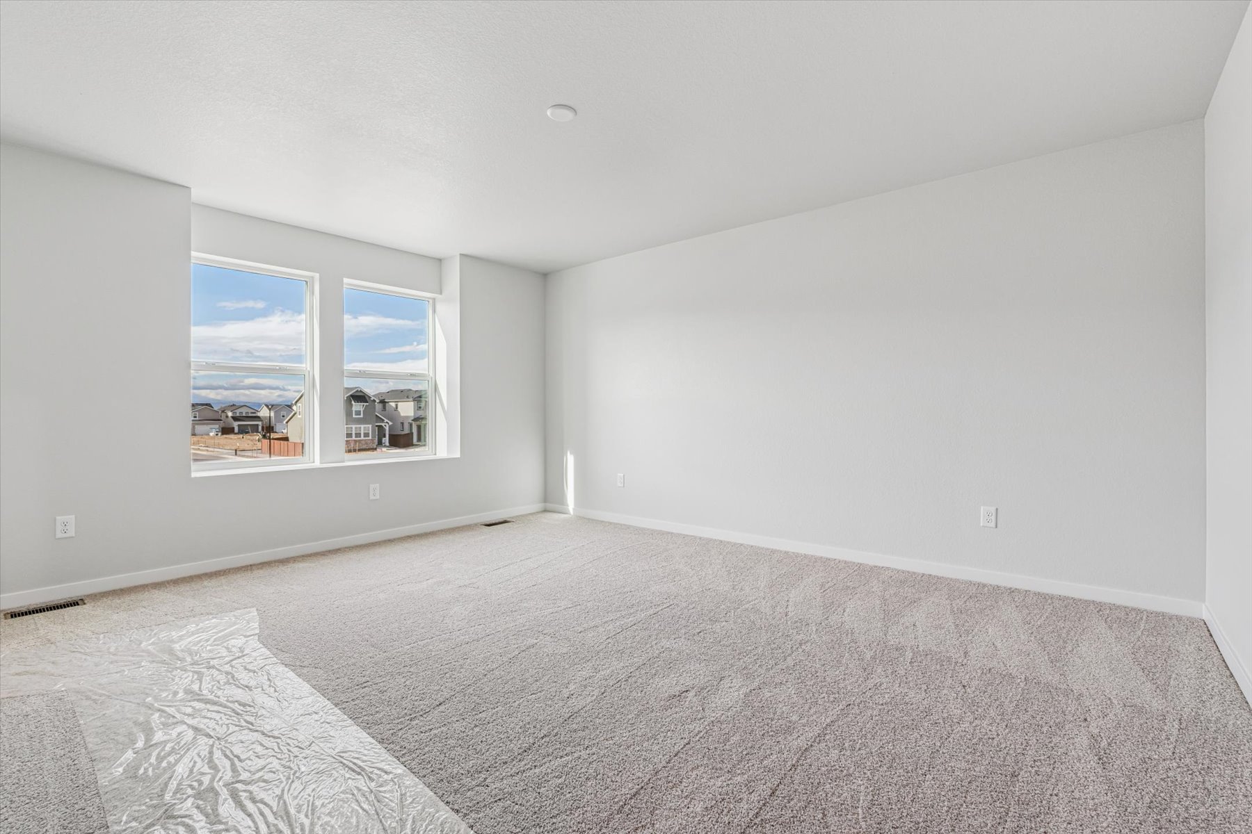 A room with a carpet and a window.