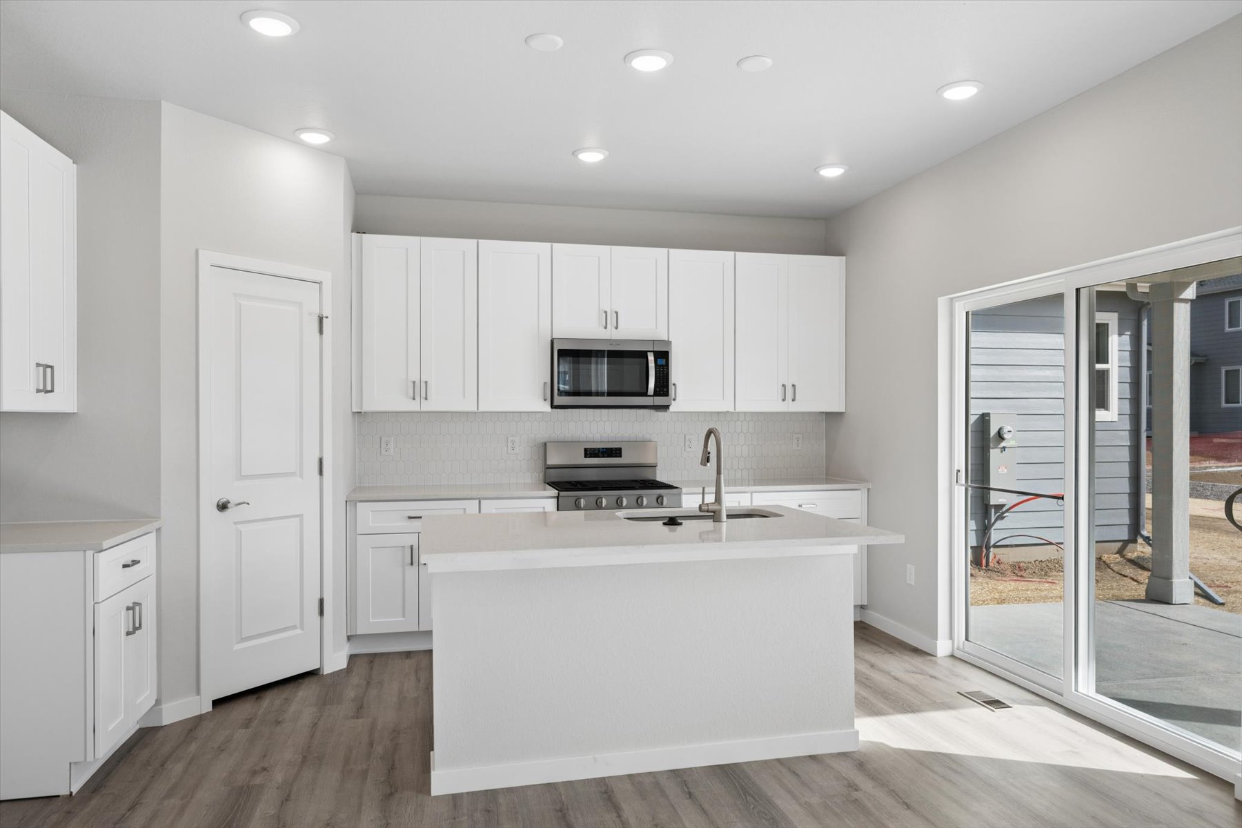 A kitchen with white cabinets.