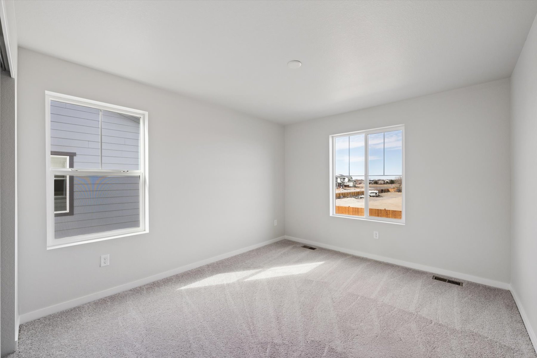 A room with a window and a rug.