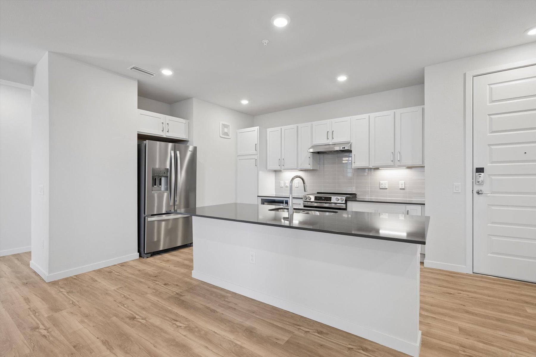 A kitchen with white cabinets.