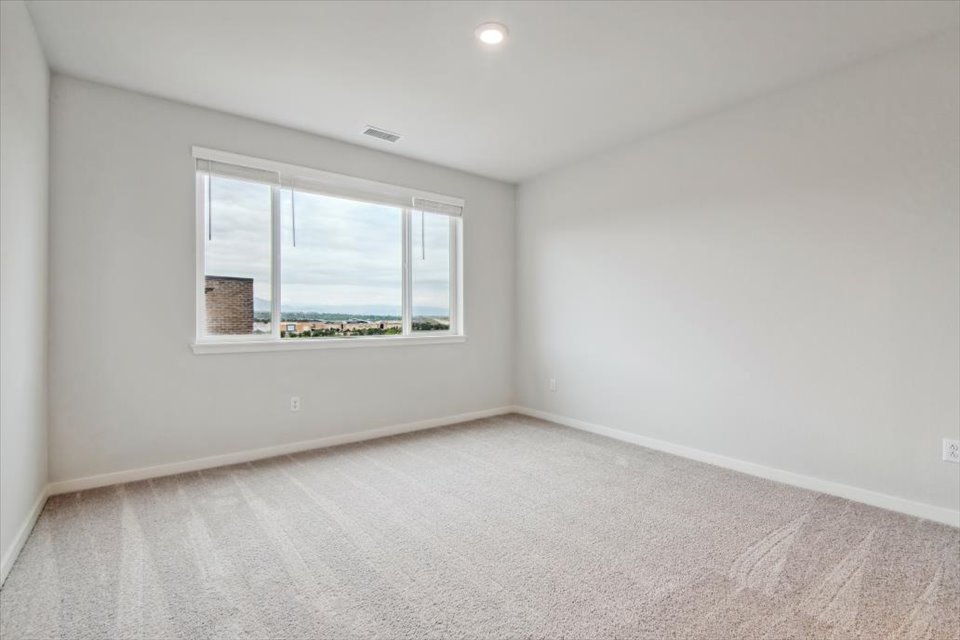 A room with a window and a rug.