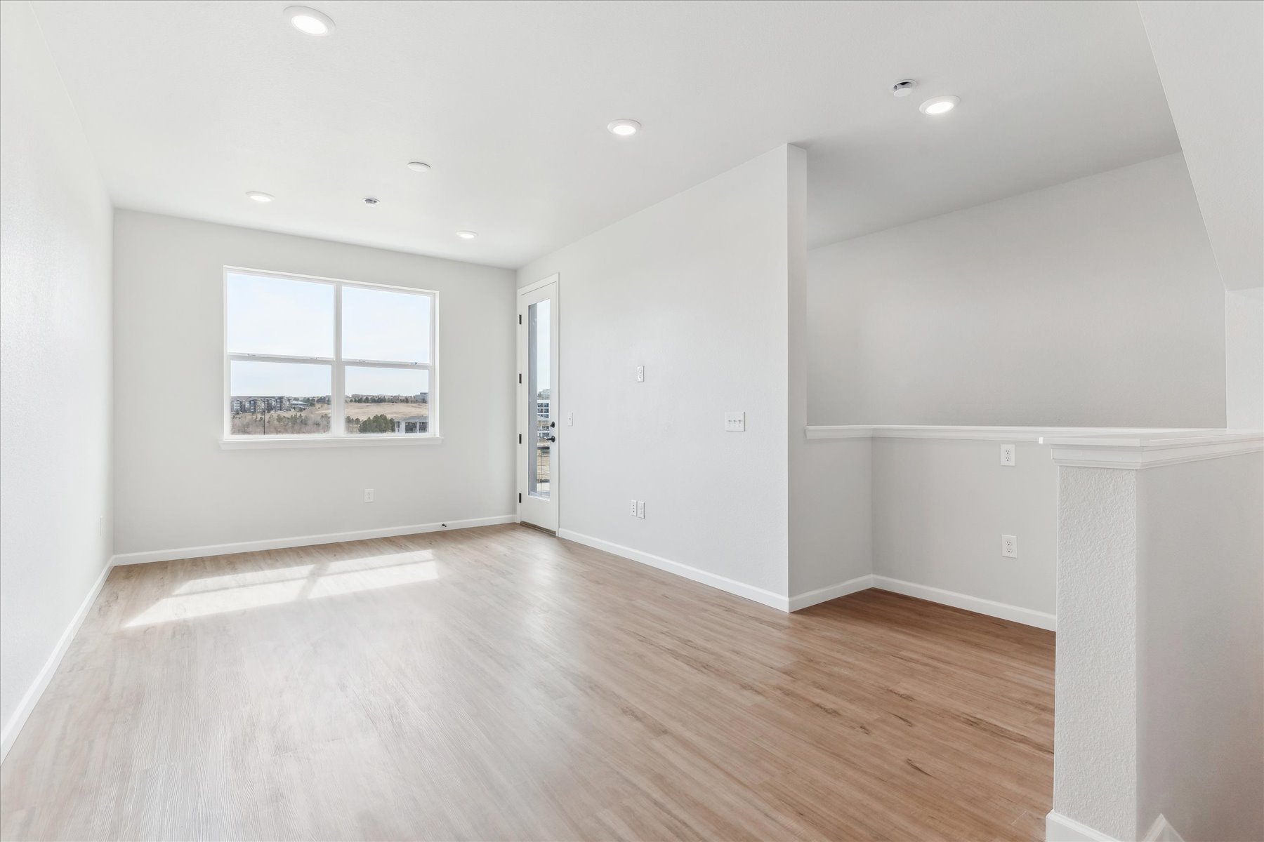 A room with a wood floor and a window.