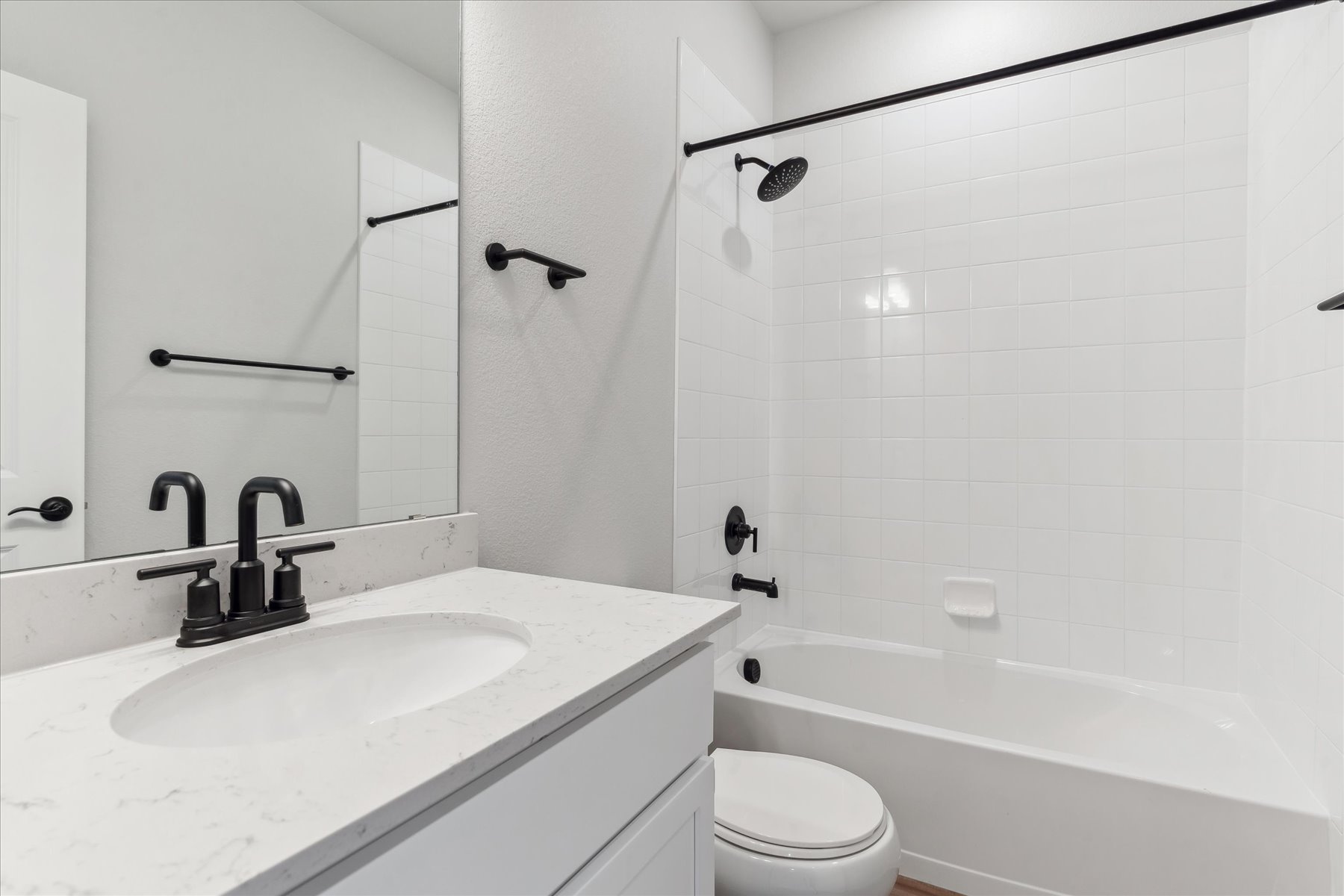 A bathroom with a tub sink and toilet.