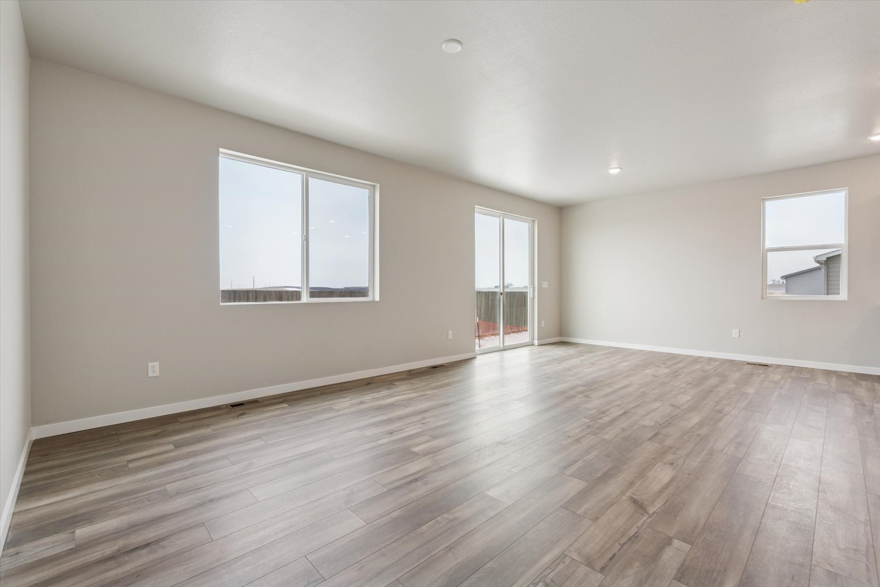 A room with a wood floor and windows.