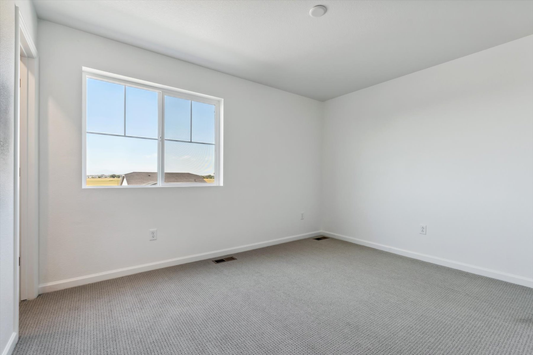 A room with a window and a carpet.