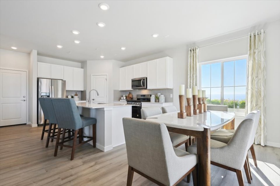 A kitchen with a dining table and chairs.