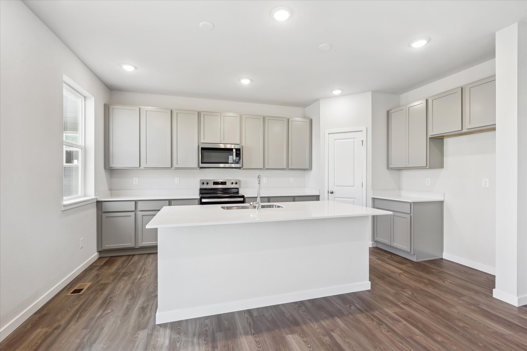 A kitchen with white cabinets.