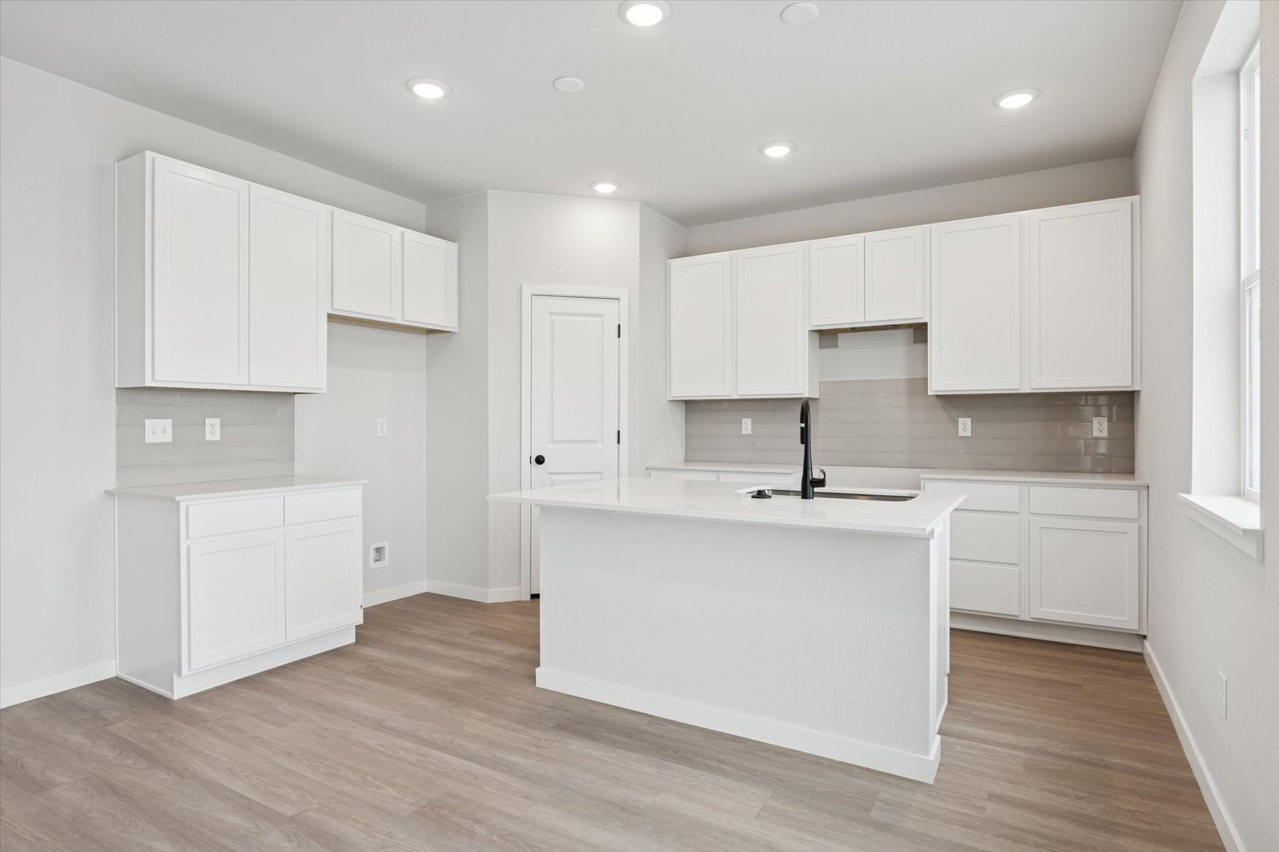 A kitchen with white cabinets.
