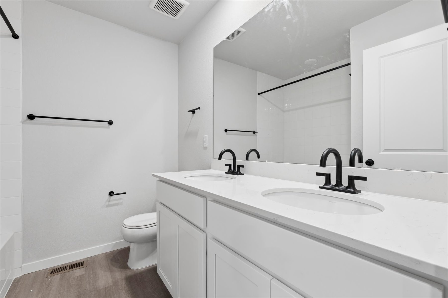 A bathroom with a sink toilet and mirror.