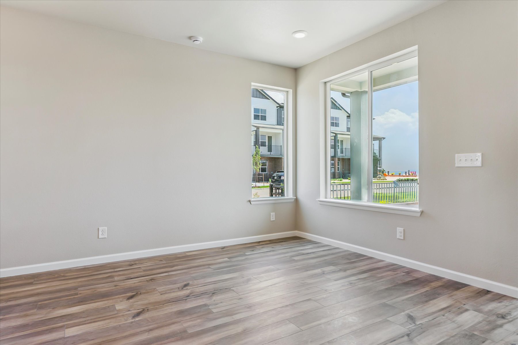 A room with a wood floor and a window with a view of the ocean.