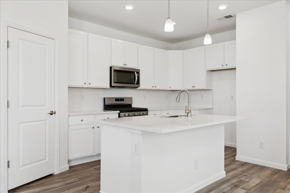 A kitchen with white cabinets.