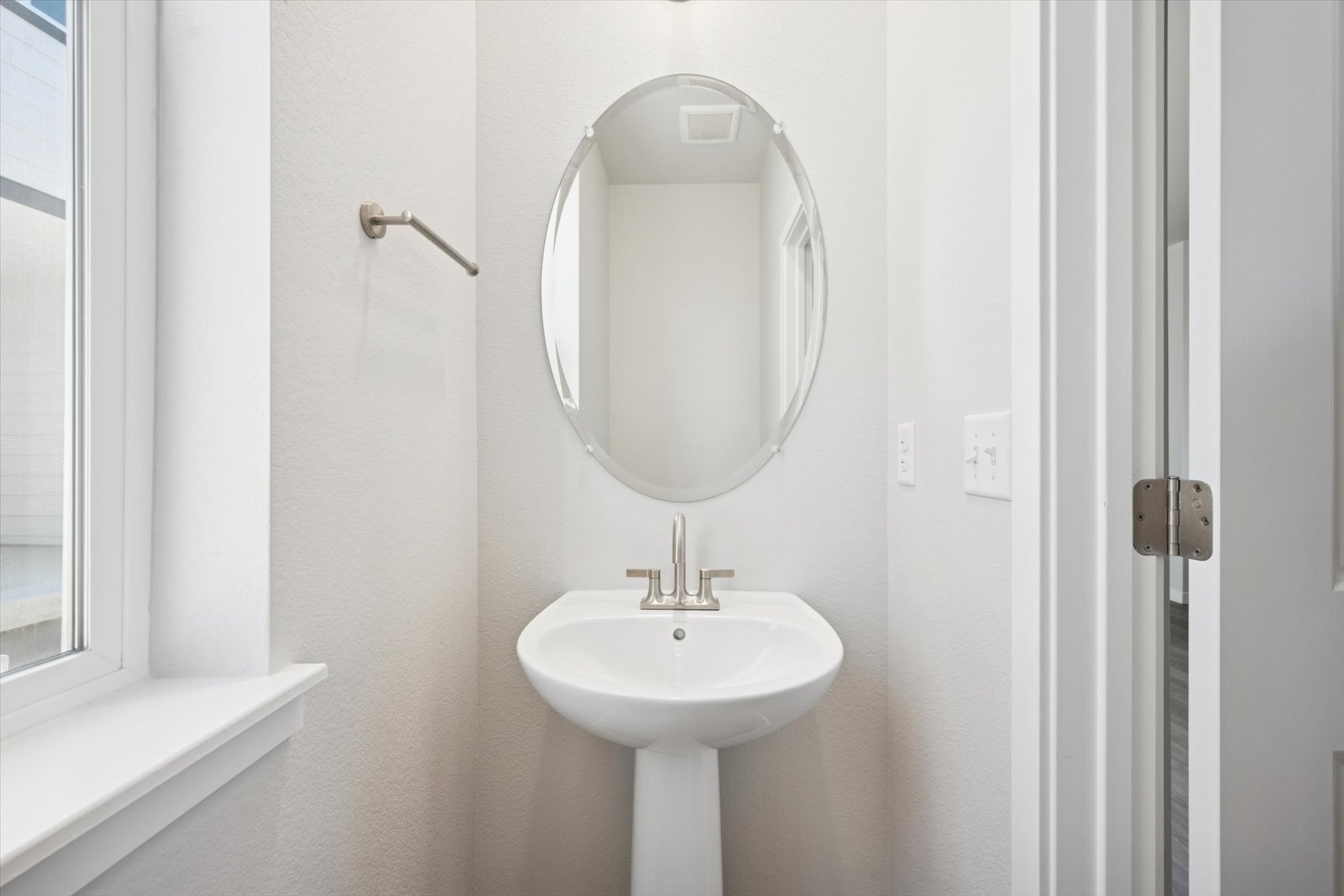 A bathroom with a round mirror.