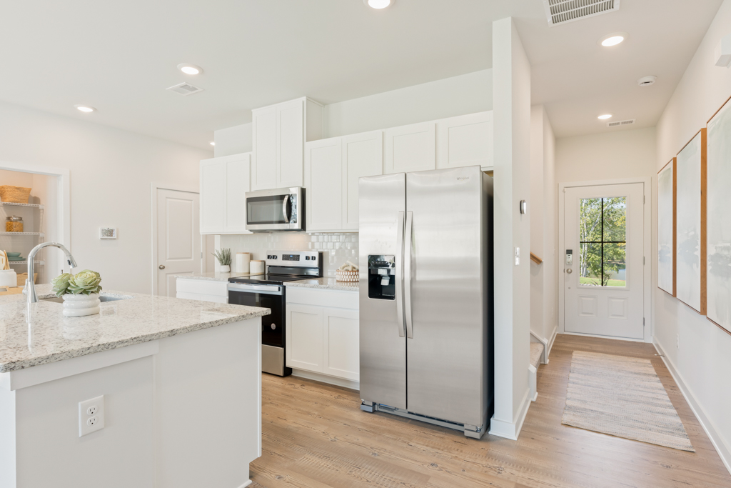 A kitchen with white cabinets.