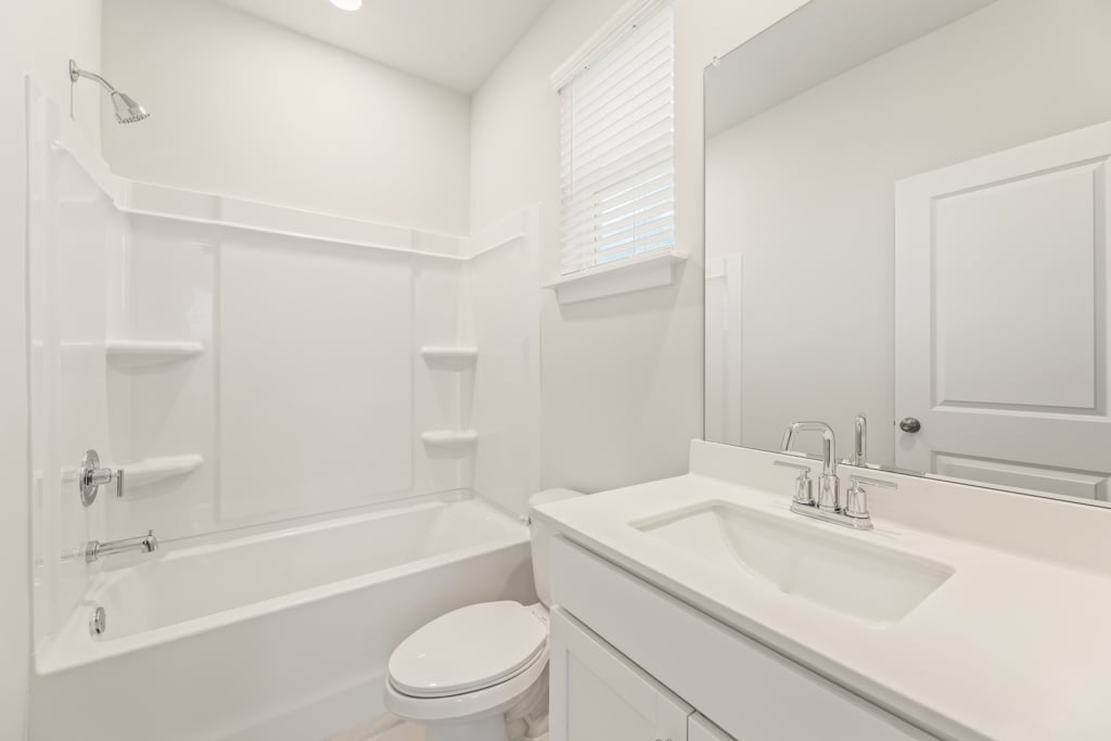 A bathroom with a tub sink and toilet.