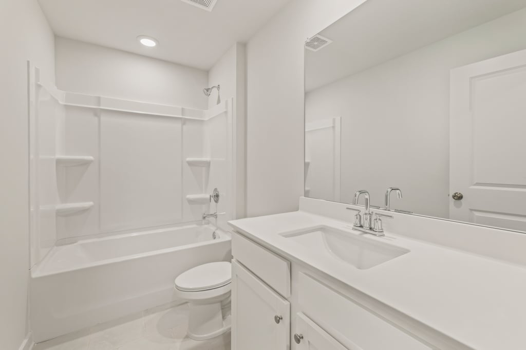 A bathroom with a tub sink and toilet.