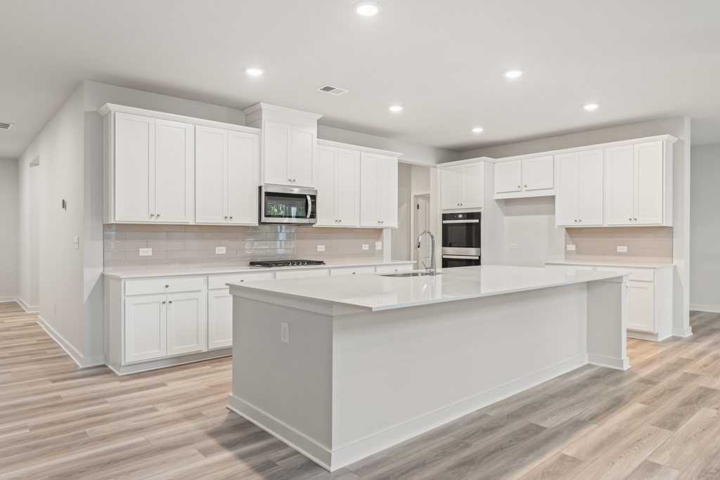 A kitchen with white cabinets.