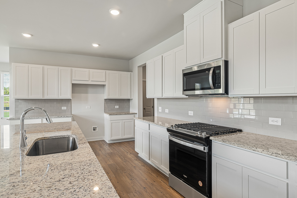 A kitchen with white cabinets.
