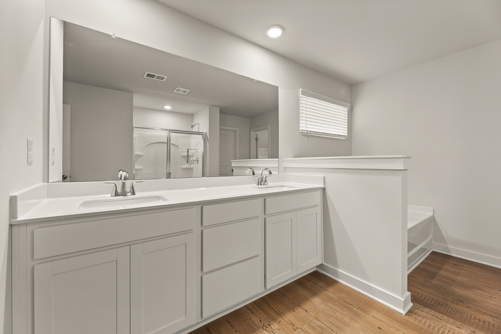 A bathroom with white cabinets.