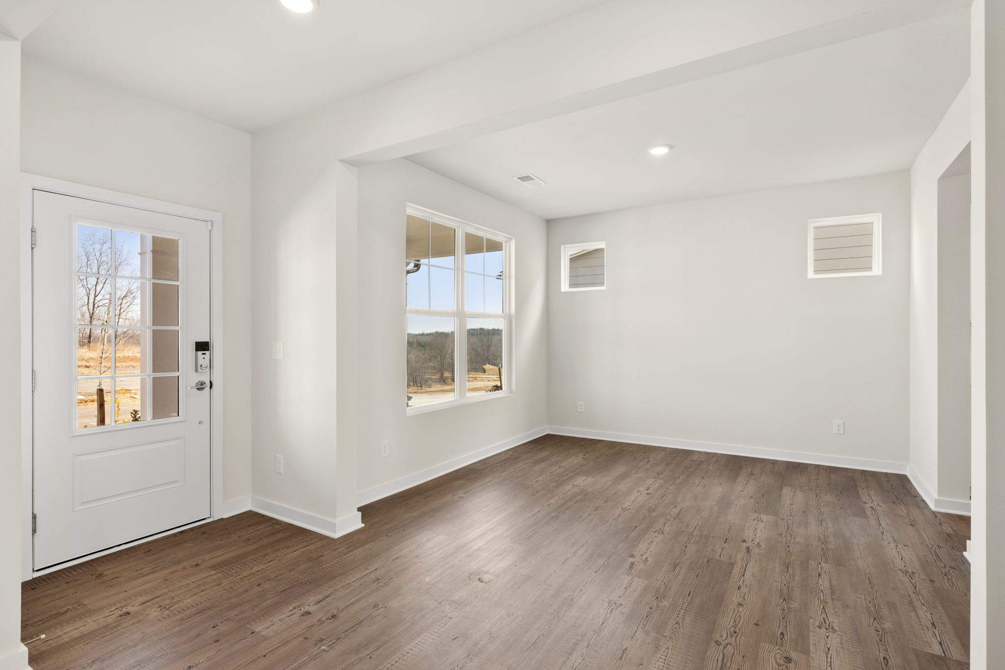A room with a wood floor and windows.