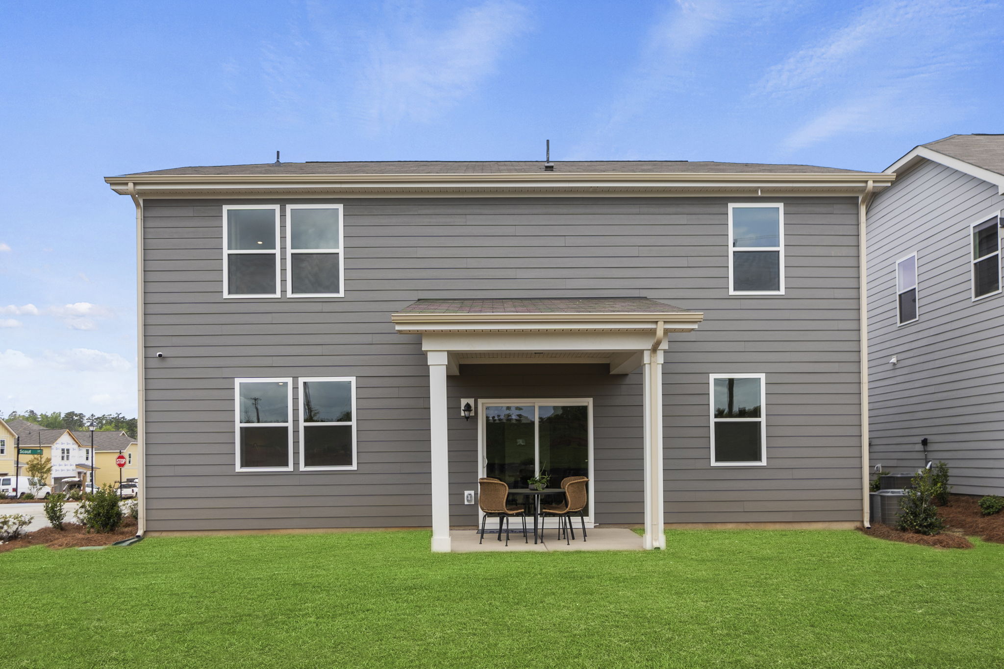 A house with a table and chairs in the front.
