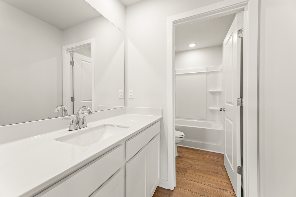 A bathroom with a tub sink and toilet.