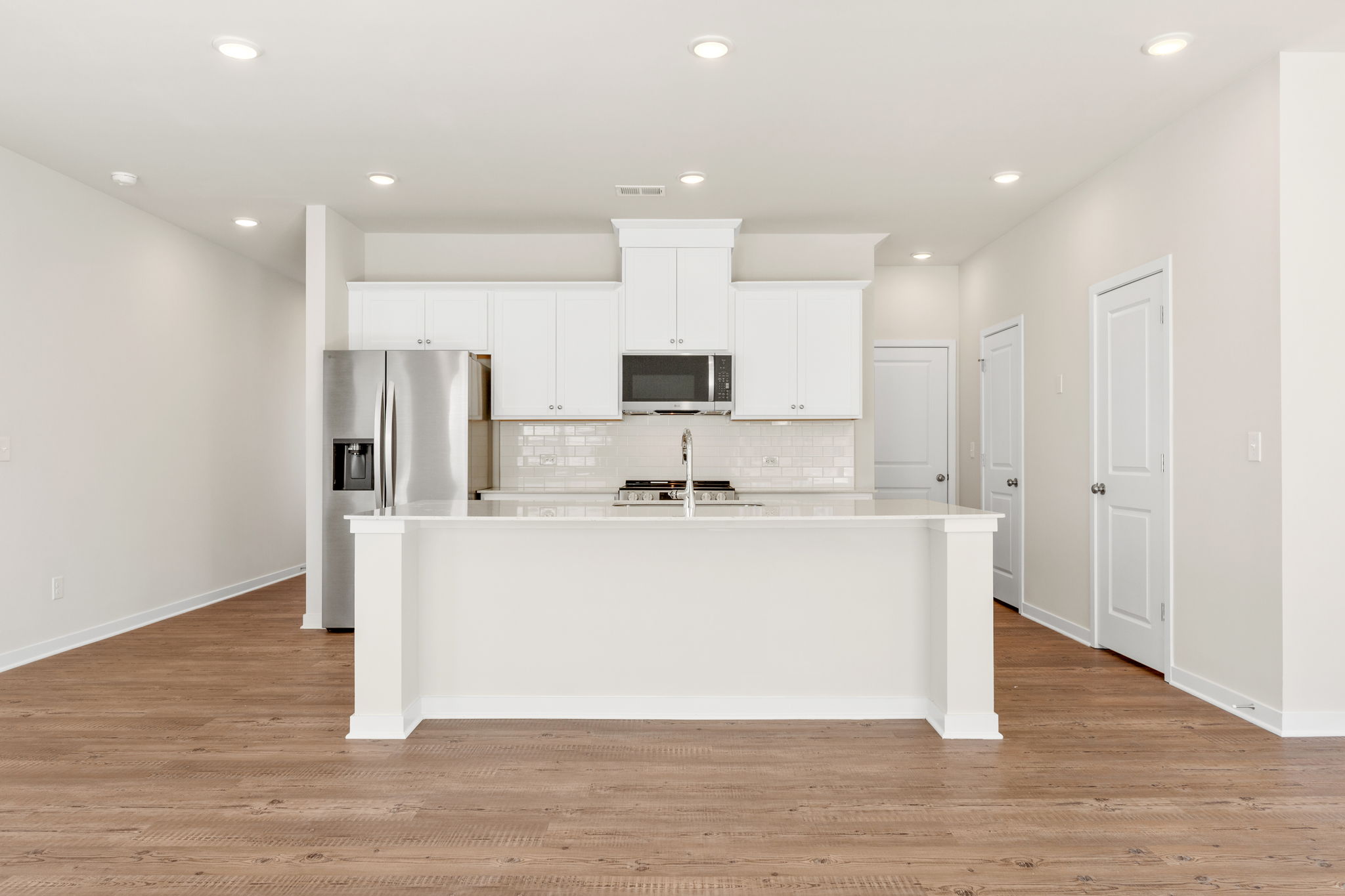 A kitchen with white cabinets.