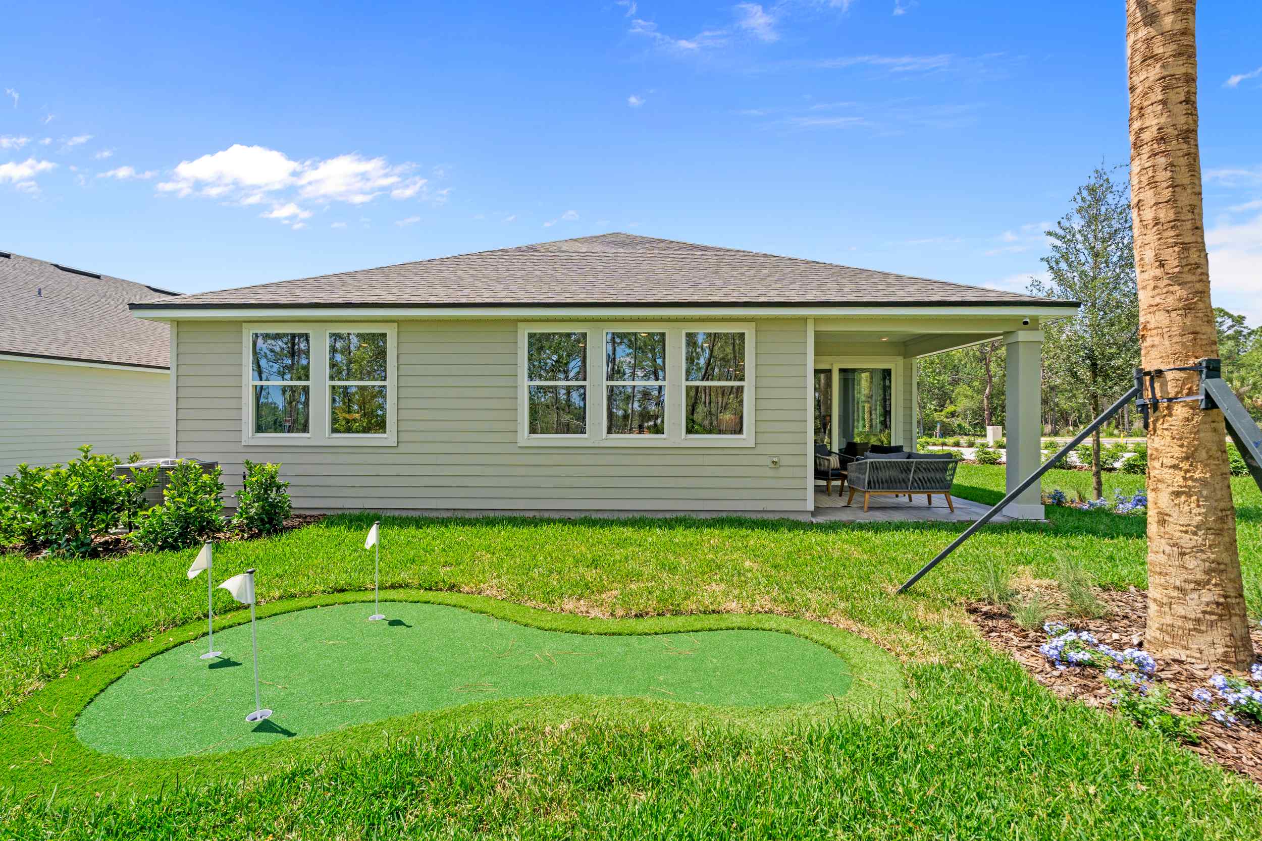 Coronado Model Home Backyard with Covered Patio and Small Putting Green at Reserve East in Flagler Beach