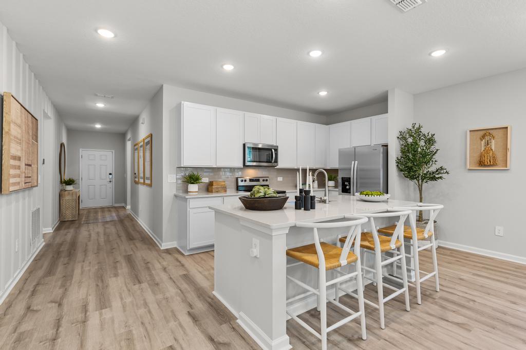 A kitchen with white cabinets.