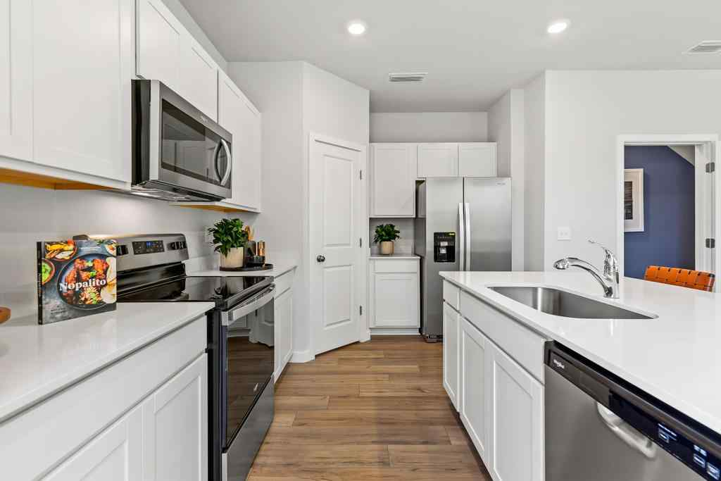 A kitchen with white cabinets.