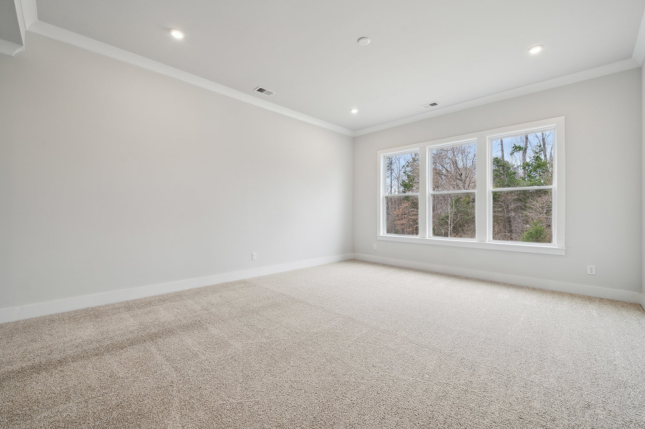 A room with a window and carpet.