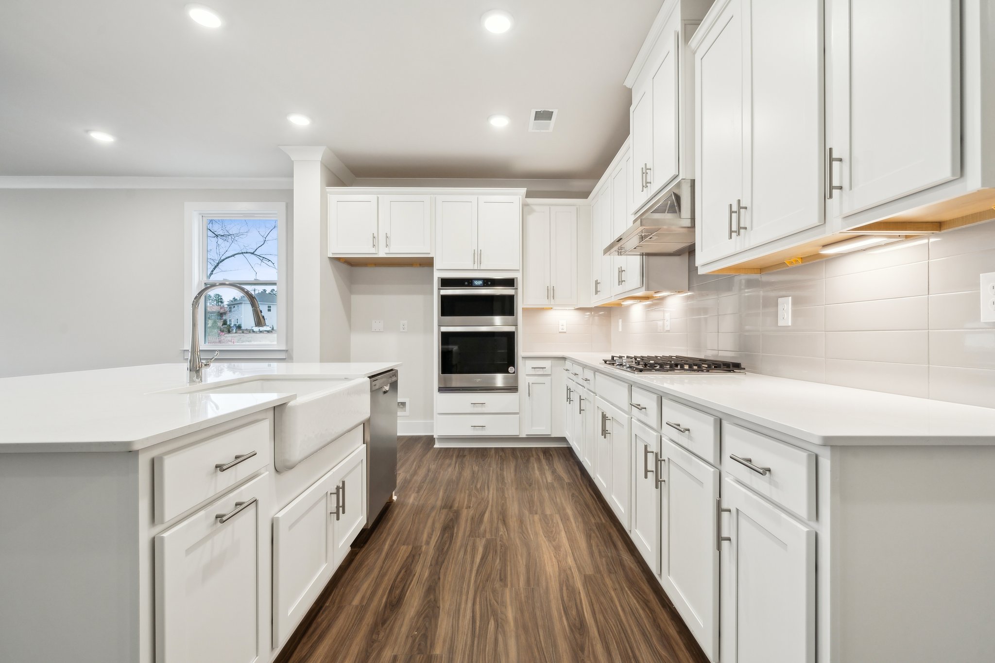 A kitchen with white cabinets.
