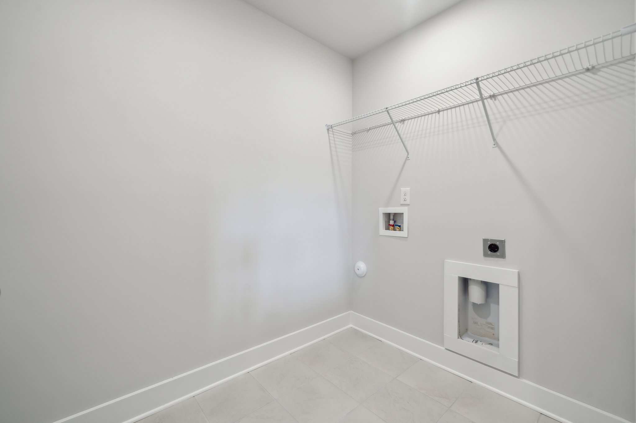 A white wall with a light switch.