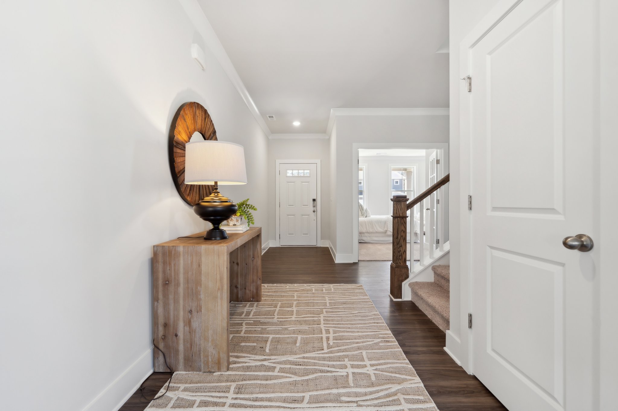 A hallway with a lamp and a mirror.