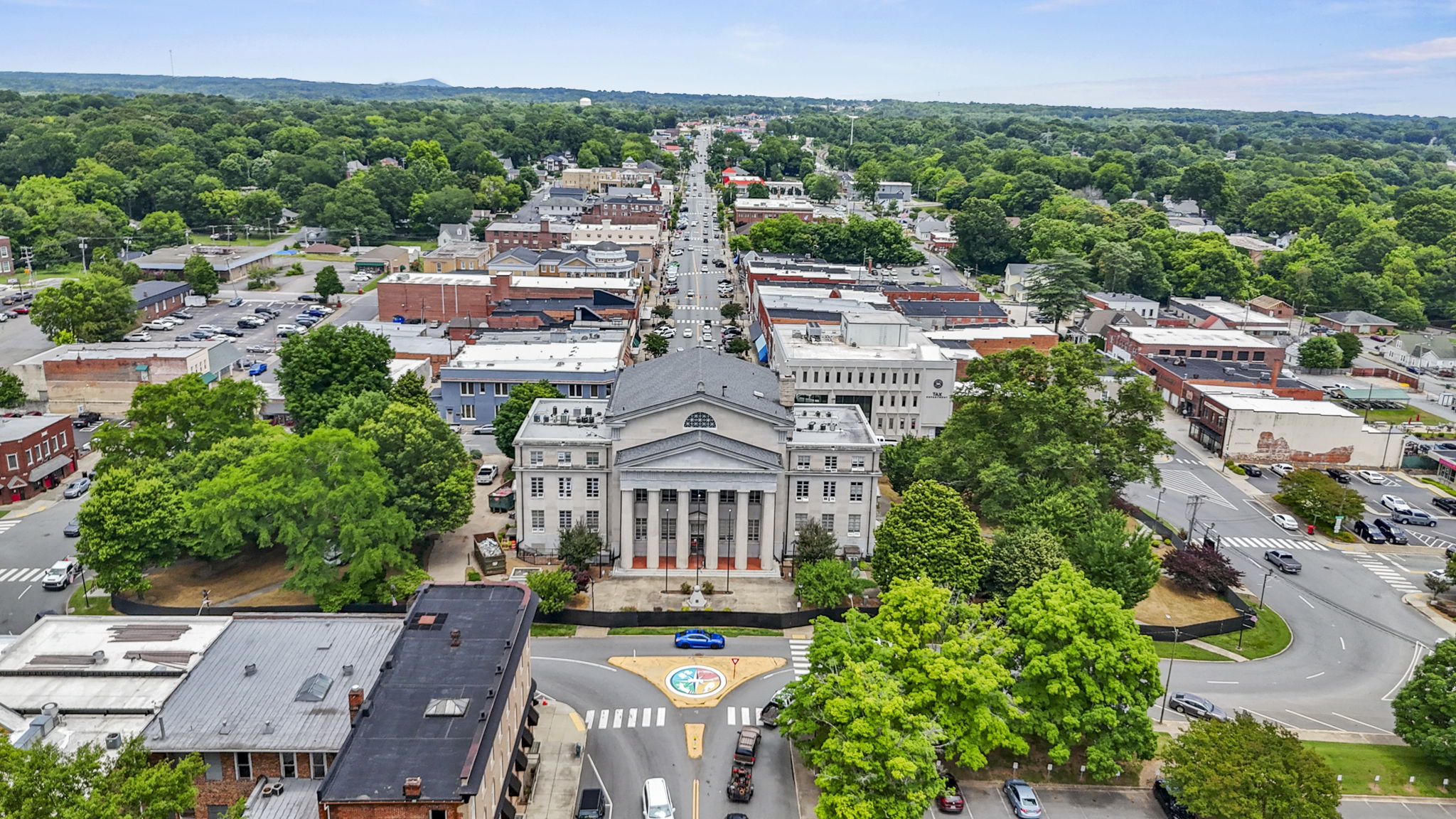 A large building with a dome and trees in front of it.