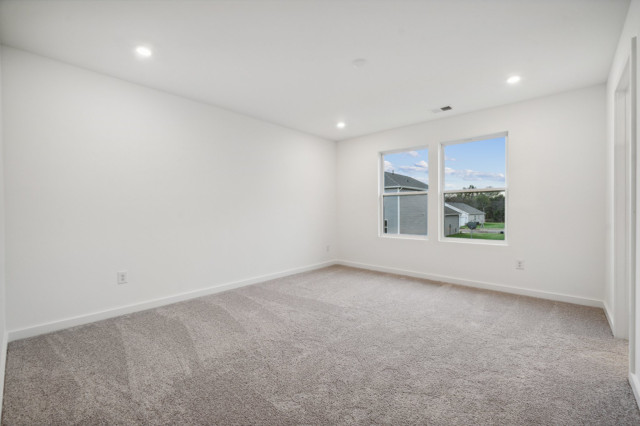 A room with a window and a carpet.
