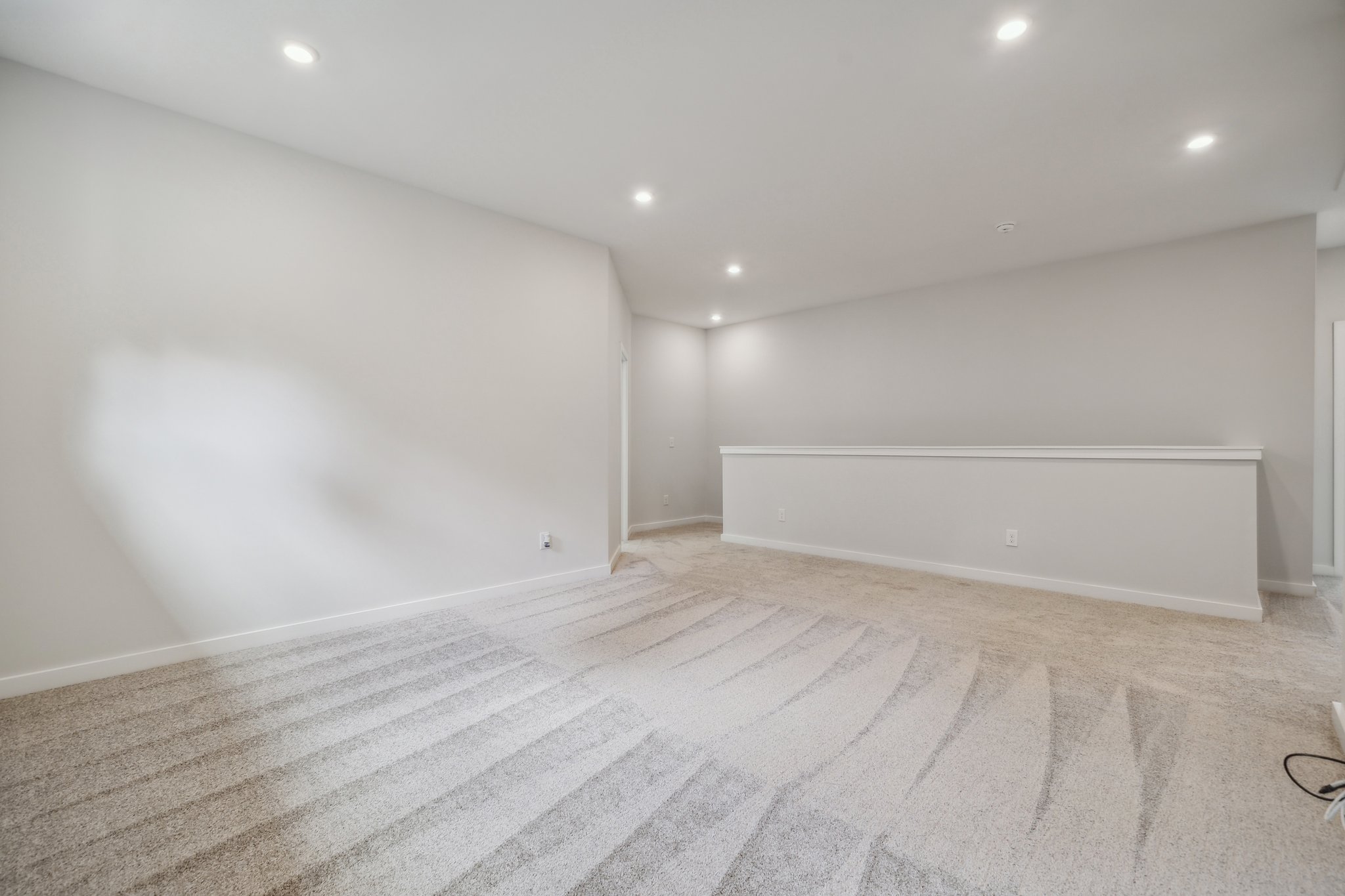 A room with a white wall and a wood floor.
