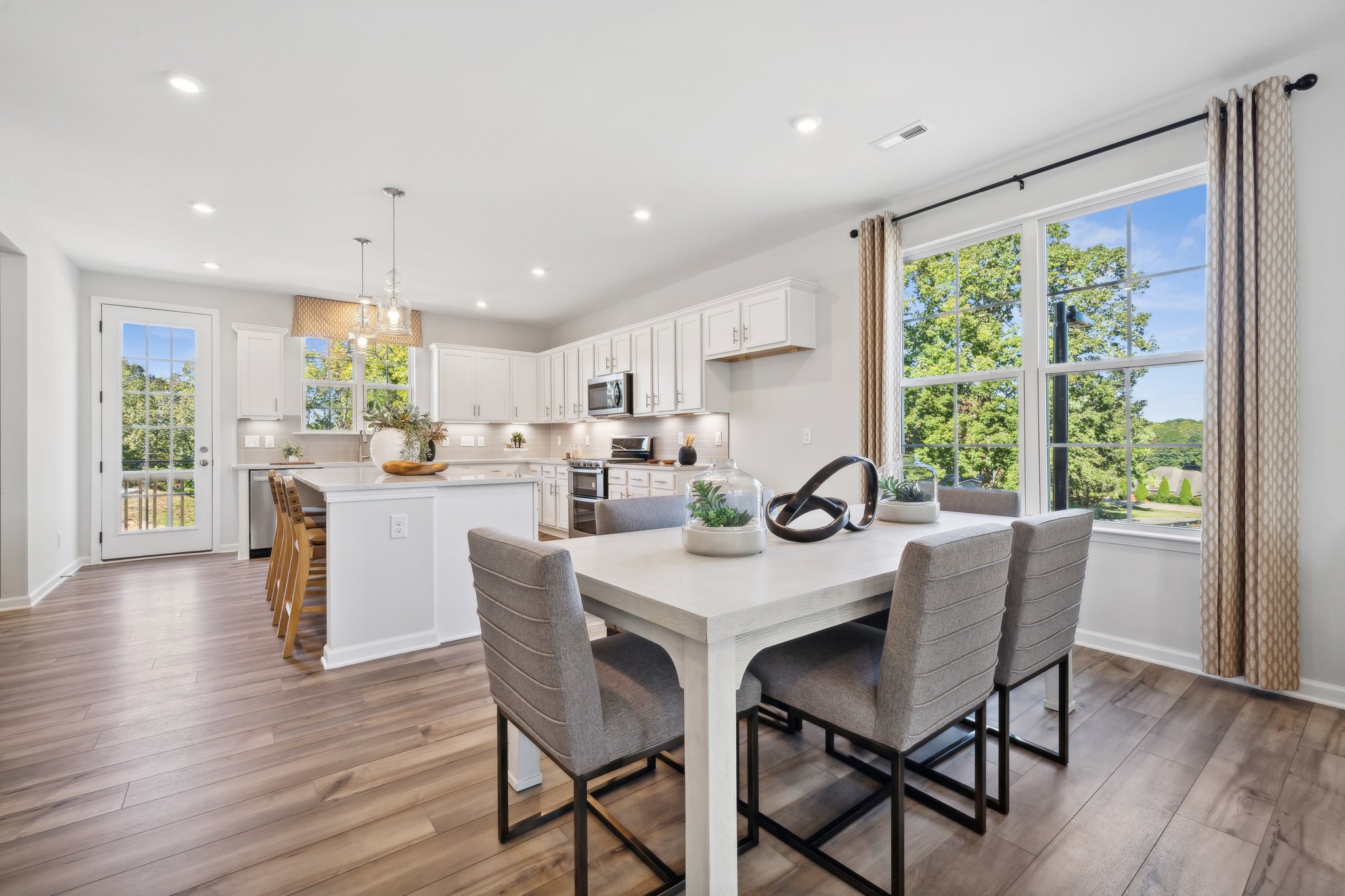 A kitchen with a dining table and chairs.
