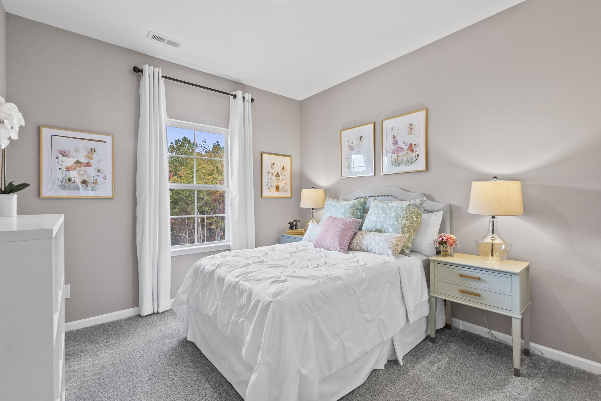 A bedroom with a bed and lamps.