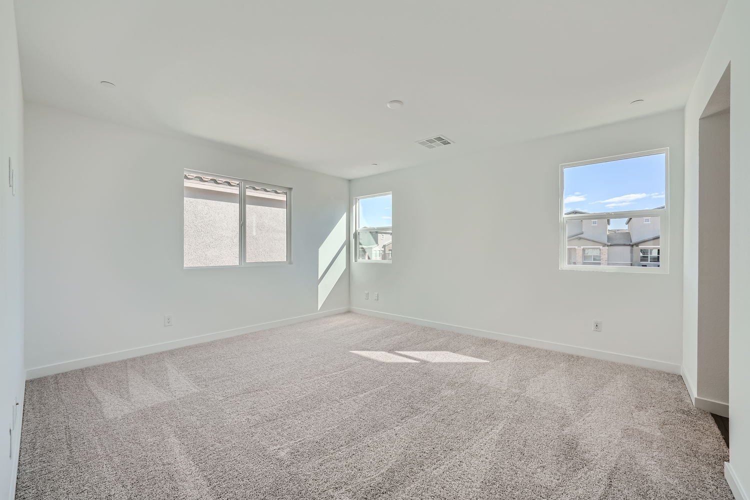 A room with a carpet and a window.