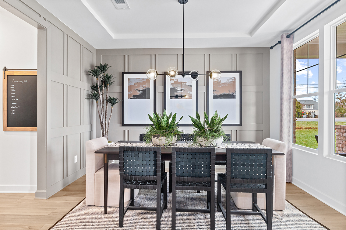 A dining room with a large table and chairs.