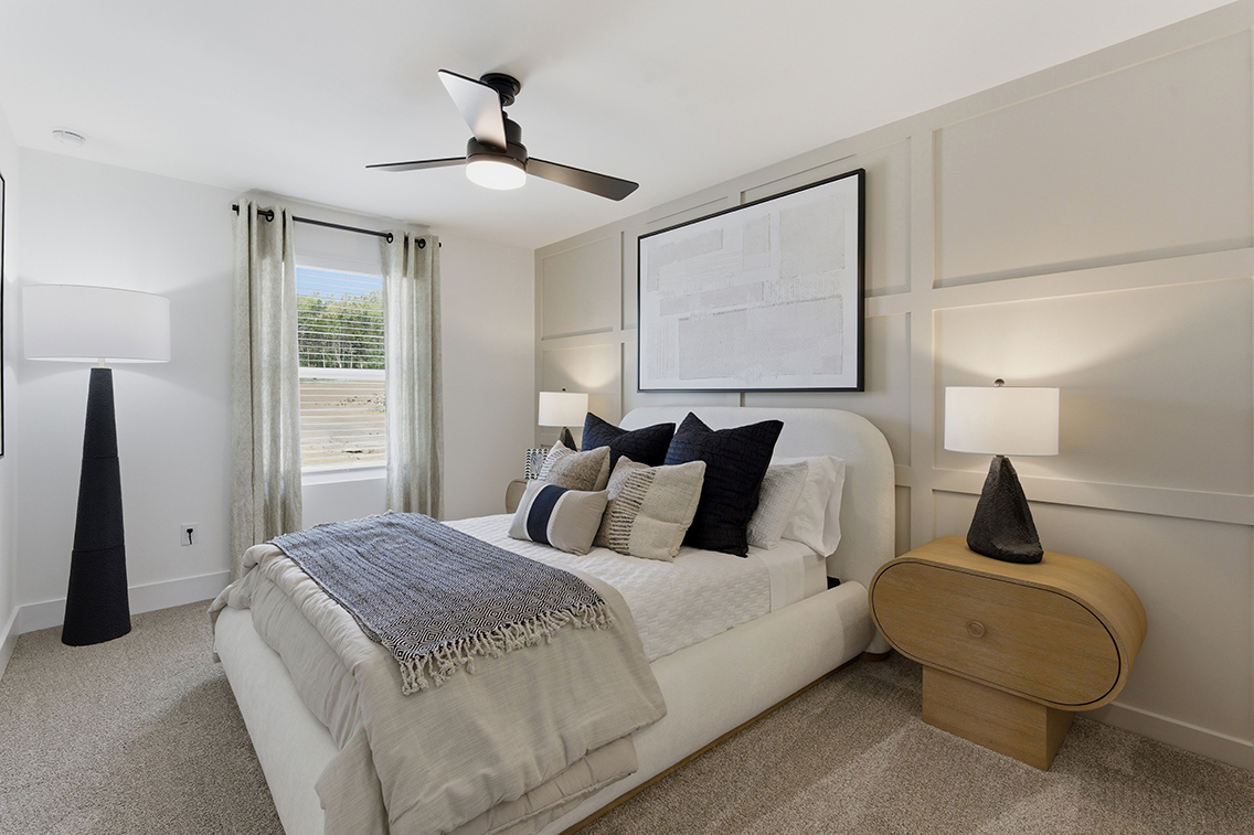 A bedroom with a bed and a table.