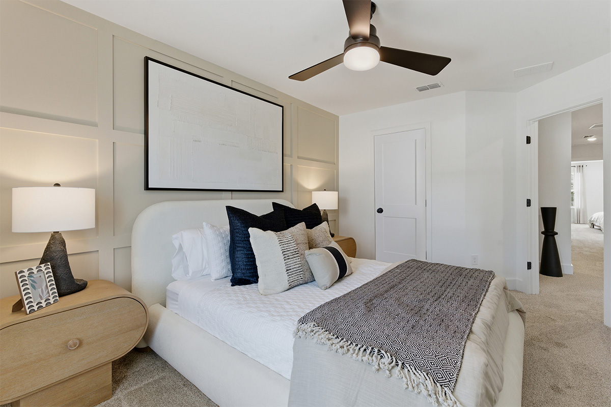A bedroom with a bed and a fan.